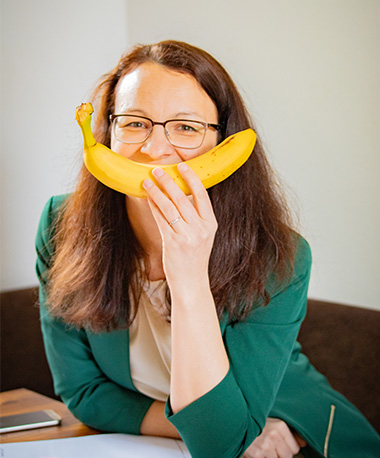 Portrait der Geschäftsführerin Liane Kainz-Wöchtl mit Banane vor dem Mund. Die Banane symbolisiert ein Lächeln. Liane Kainz-Wöchtl ist Inhaberin der Marketing-Agentur und Werbeagentur Lianes Marketing mit Sitz in Waidhofen an der Thaya.